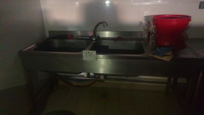a sink in a kitchen with two red buckets on the counter