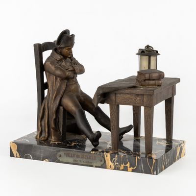 statue représentant un homme assis à un bureau sur lequel est posée une lampe