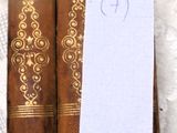 Plusieurs vieux livres sont alignés sur une table, avec une note accrochée à chacun d'entre eux.