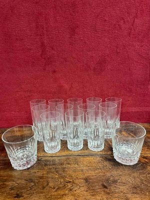 six verres transparents posés sur une table en bois près d'un mur rouge