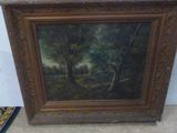 une peinture à l'huile représentant un paysage boisé, dans un cadre en bois