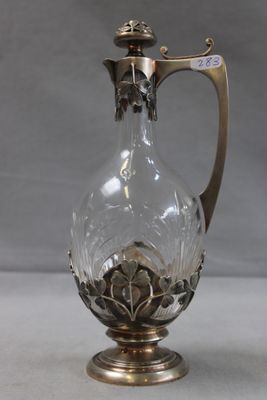 an image of a glass vase with a metal handle on a table