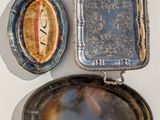 two silver trays and a mirror on a white surface