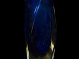 a blue glass vase with a gold rim sitting on a black surface