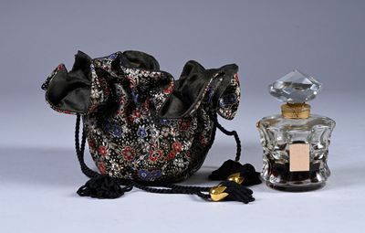 a small bag with a bottle of perfume next to it