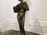 statue en bronze représentant une femme tenant un panier posé sur une table en marbre