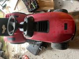 a red lawn mower parked in a garage