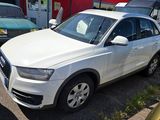 the white audi suv is parked in front of a gas station