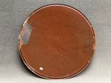 a brown plate with a white dot on it