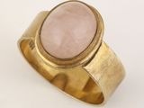 gros plan d'une bague en or avec une pierre rose