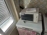 un four à micro-ondes posé sur un réfrigérateur dans une cuisine