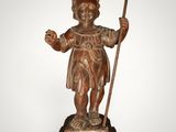 statue of a boy with a staff and a cross