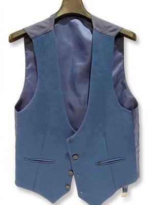 the blue vest is hanging on a hanger on the wall