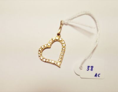 a small gold heart charm hanging from a white string