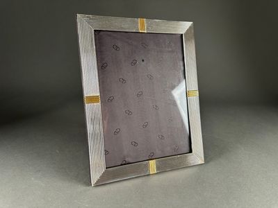 silver and gold photo frame with hearts on it on a table