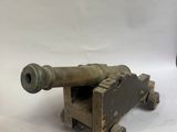 un petit canon en bois posé à côté d'un autre canon en bois, plus petit