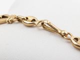 an image of a close up of a gold bracelet on a white surface