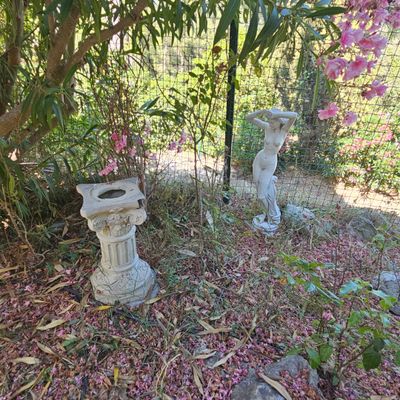 deux statues assises dans l'herbe près d'un arbre