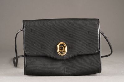 un sac à main noir orné d'un anneau doré sur le devant