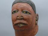 une image d'un masque en bois sur un support