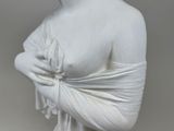 a white statue of a woman with a scarf around her neck