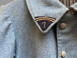 a close up of a blue jacket with a black and white striped collar
