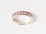 an image of a ring with pink stones on a white surface