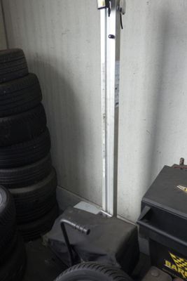 un tas de pneus dans un garage, à côté d'une machine à démonter les pneus