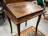 un bureau en bois avec un plateau en bois, dans une pièce remplie de meubles