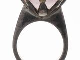 an image of a close up of a ring with a pink stone on it