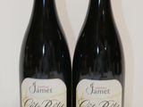 two bottles of red wine sitting on a table next to each other