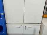 deux réfrigérateurs blancs et une armoire bleue dans une pièce