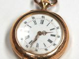 a gold pocket watch with roman numerals on it