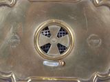 a gold plate with a fan on top of it