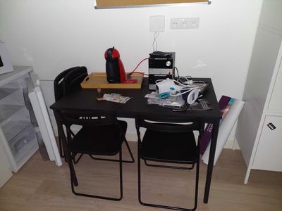 a black table with two chairs and a computer on it