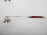 a silver spoon and a wooden handle on a white surface