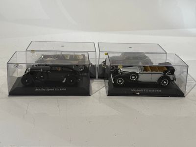 two model cars in a display case on a white surface