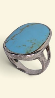 an oval turquoise stone ring set in a silver setting