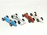 four toy race cars lined up on a white surface