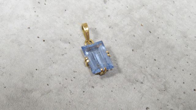 Pendentif à décor d’une pierre bleue facettée rectangulaire en or...