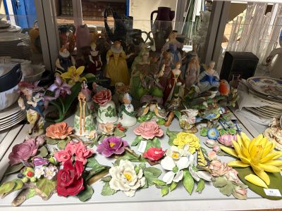 une table sur laquelle sont disposées de nombreuses fleurs et figurines