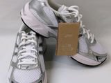 a pair of white and silver sneakers with a tag on them