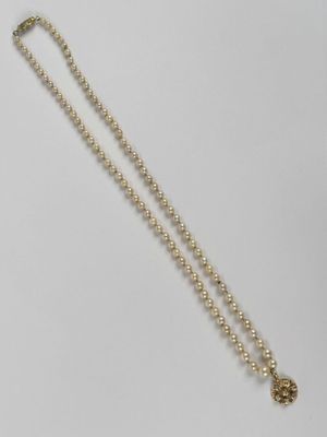 un collier en or avec une chaîne à perles rondes