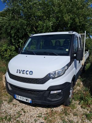 un camion blanc garé sur le bord de la route