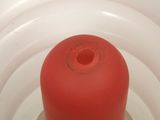 a red object in the middle of a white container