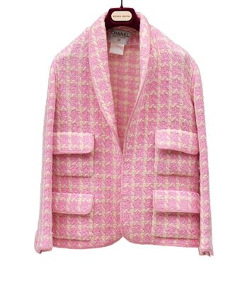 une veste rose suspendue à un cintre sur un mur blanc
