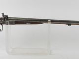 un vieux fusil au canon en bois, posé sur un socle transparent