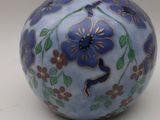 a blue vase with flowers on it sitting on a table
