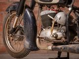 an old motorcycle that is parked in front of a brick wall