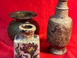 two vases sitting next to each other on a red cloth